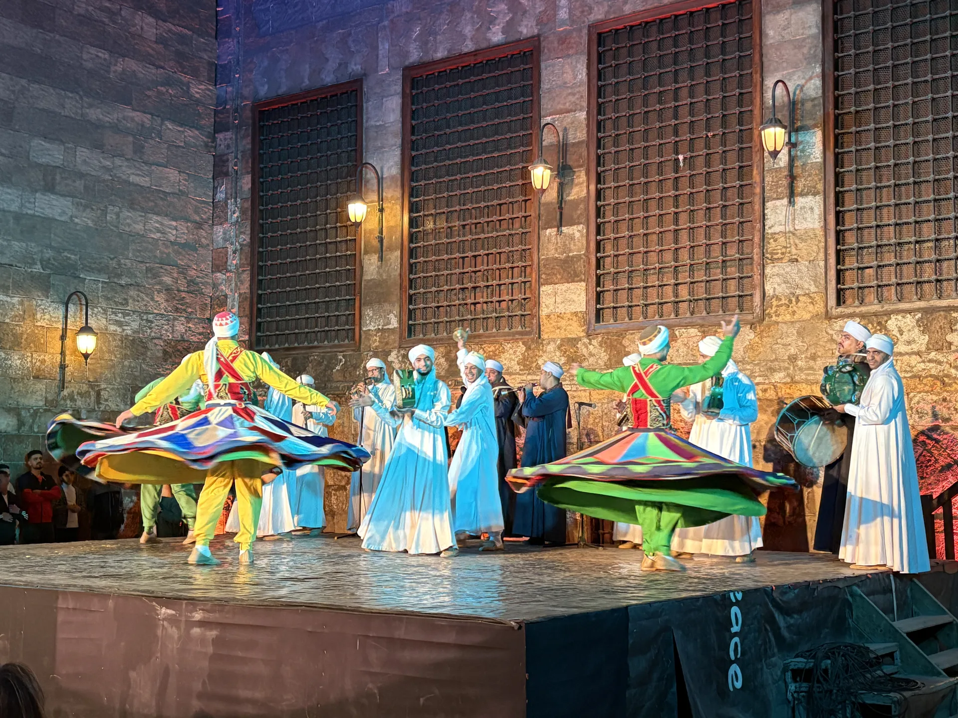 Tanoura dancers in colourful spinning skirts performing with live musicians at Wekalet El Ghouri, Cairo