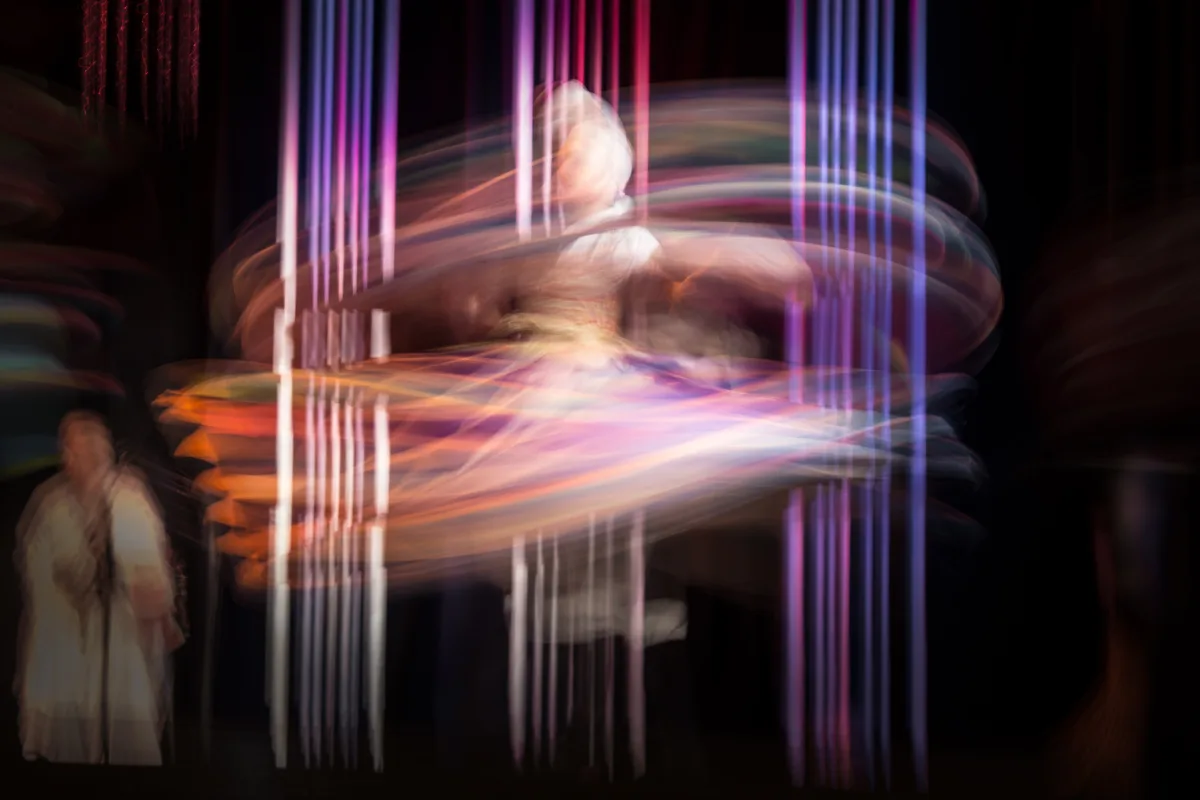 A long-exposure photograph capturing the blur of a Tanoura dancer's spinning skirt